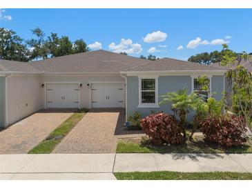 Charming home showcasing a two-car garage, brick driveway, and colorful landscaping at 1841 Overcup Ave, St Cloud, FL 34769