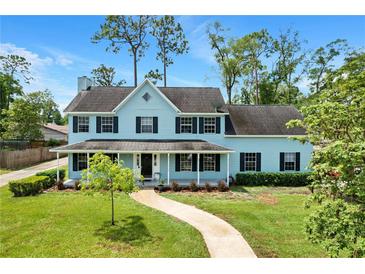 Charming two-story home with a covered front porch and well-manicured lawn at 201 Garden Ln, Longwood, FL 32750