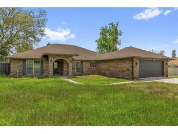Charming brick home featuring an arched entryway, a two-car garage, and lovely curb appeal at 3 Pine Glen Dr, Debary, FL 32713
