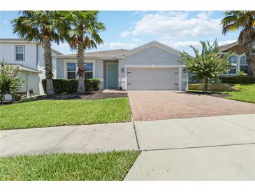 Charming single-Gathering home with a well-manicured lawn, a two-car garage and a brick paver driveway at 3142 Hill Point St, Minneola, FL 34715