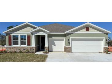 Charming single-Gathering home with a two-car garage and stone accents on the facade at 3305 Arch Ave, Ormond Beach, FL 32174