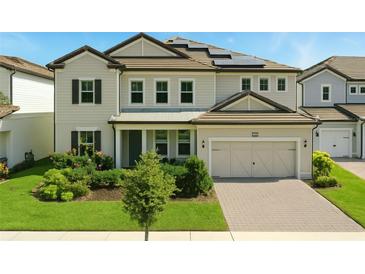 Charming two-story home with a well-manicured lawn, lush landscaping, and a two-car garage at 7613 Wandering Way, Orlando, FL 32836