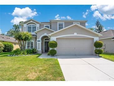 Charming two-story home featuring a well-manicured lawn and an attached two-car garage at 9846 Palmetto Dunes Ct, Orlando, FL 32832