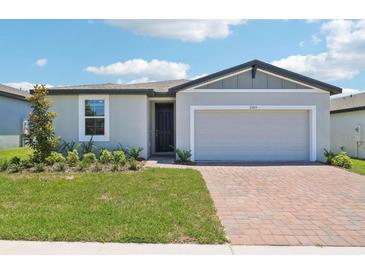Charming single-story home with a well-manicured lawn and a brick driveway, offering great curb appeal at 2365 White Tail St, Davenport, FL 33837