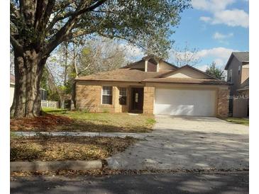 Charming brick home with a two-car garage and well-maintained front yard at 3013 Barrymore Ct, Orlando, FL 32835