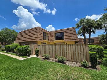 Charming townhome featuring a unique roof, fenced yard, and lush landscaping at 5288 Cypress Ct # 439, Orlando, FL 32811