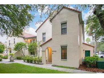 Exterior of a two-story home featuring a red tile roof and beige stucco walls, surrounded by lush landscaping at 710 Siena Palm Dr # 104, Celebration, FL 34747
