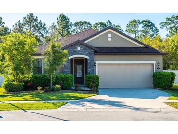 Charming single-story home with stone accents, manicured landscaping, and an attached two-car garage at 113 San Mardeen Ct, Daytona Beach, FL 32117