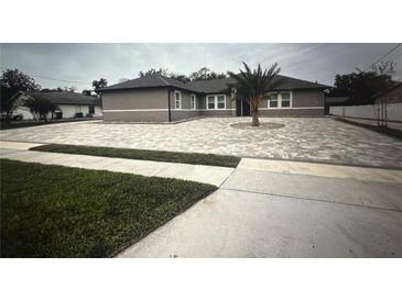 Beautiful one story home with long driveway and decorative front yard with a palm tree at 2420 Graham Dr, Orlando, FL 32807
