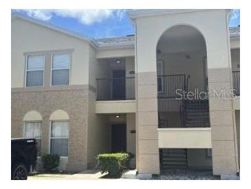 A multi-level exterior view of a condominium building with beige stucco and dark trim at 2770 Club Cortile Cir # A, Kissimmee, FL 34746