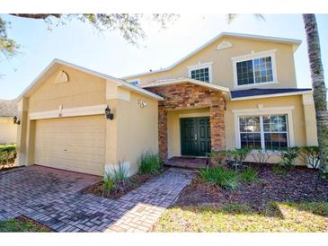 Charming two-story home with a two car garage, stone accents, and well-maintained landscaping at 331 Bridgewater Dr, Davenport, FL 33897