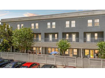 Charming townhome with grey exterior, white picket fence, and balconies for a relaxing outdoor living experience at 660 Celebration Ave # 250, Kissimmee, FL 34747