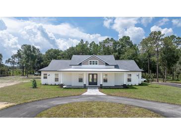 Stunning single-story home featuring a welcoming front porch and circular driveway at 10750 Sw 110Th St, Dunnellon, FL 34432