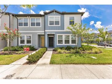 Charming townhome featuring blue and gray exterior, manicured lawn, and inviting curb appeal at 3303 Azolla St, Orlando, FL 32808