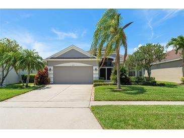 Well-maintained single-Gathering home with a lush lawn, mature trees, and a two-car garage at 3419 Fernwood Dr, Kissimmee, FL 34741
