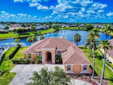 Expansive home featuring lake view, mature landscaping, and a grand front entrance, promising luxurious living at 3728 Hunters Isle Dr, Orlando, FL 32837