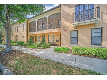 Attractive two-story condo exterior with manicured landscaping, walkway, porch and balcony at 506 Mirasol Cir # 202, Celebration, FL 34747