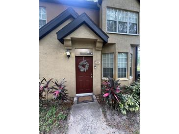 Inviting front entrance with a decorative wreath on the red door and well-maintained landscaping at 6328 Raleigh St # 814, Orlando, FL 32835