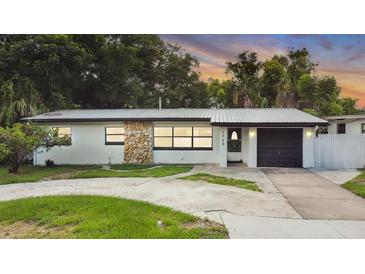 Charming single-story home featuring a stone accent wall and well-manicured lawn at 1148 Northcrest Dr, Apopka, FL 32703