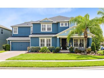 Charming two-story home boasts a manicured lawn, blue exterior, and inviting front porch at 11850 Sheltering Pine Dr, Orlando, FL 32836