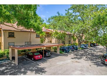 A well maintained apartment complex with mature landscaping, covered parking, and a terracotta tile roof at 1217 Salerno Ct # 1217, Orlando, FL 32806