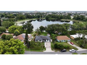 Beautiful aerial view of home with solar panels, pond, and lush landscaping at 2154 Lake Christie Dr, Orlando, FL 32809
