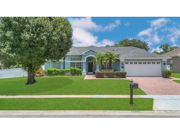 Charming single-story home with a well-manicured lawn, mature trees, and a brick driveway at 2674 Sugar Pine Run, Oviedo, FL 32765