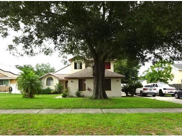 Charming home featuring a well-manicured lawn and mature trees providing ample shade at 3017 Lambath Road, Orlando, FL 32818