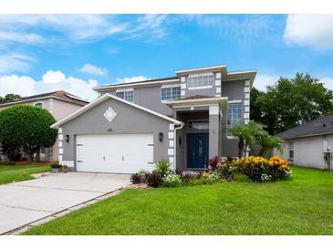 Charming two-story home with a manicured lawn and a freshly painted gray exterior at 415 Eastbridge Dr, Oviedo, FL 32765