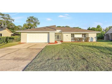 Charming single-story home featuring a well-manicured lawn, driveway, attached garage, and inviting front entrance at 520 Eagle Cir, Casselberry, FL 32707