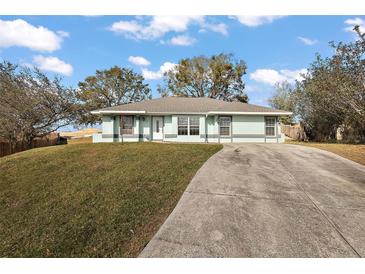 Charming single-story home featuring a well-manicured lawn and a concrete driveway on a sunny day at 12419 Eryn Ct, Clermont, FL 34711