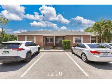 Charming brick duplex features a well-maintained facade with dedicated parking spaces for residents and guests at 1288 Americana Pl, Orlando, FL 32807