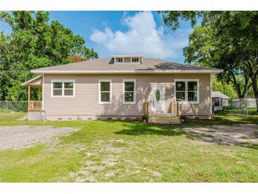 Inviting single-story home with charming curb appeal, lush lawn, and mature shade trees at 1480 Wauchula St, Intercession City, FL 33848