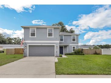 Charming two-story home featuring a manicured lawn, two car garage and lovely curb appeal at 2032 Wavyleaf Ct, Apopka, FL 32712
