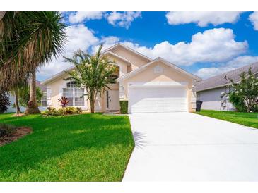 Charming single Gathering home with a well maintained lawn, bright driveway, and lovely blue sky at 207 Langham Dr, Davenport, FL 33897