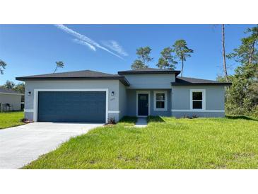 Charming single-story home with a well-manicured lawn, attached garage, and inviting front entrance at 2500 Sw 156Th Ln Rd, Ocala, FL 34473