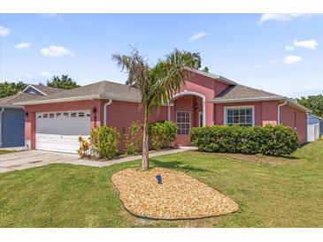Charming pink single-story home with a two-car garage and well-maintained front yard at 2513 Hickory Oak Blvd, Orlando, FL 32817