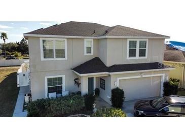 Two story home featuring an attached garage, manicured shrubbery, and neutral stucco exterior at 376 Willet Street Willet St, Haines City, FL 33844