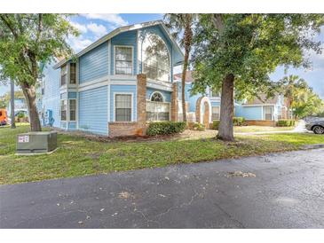 Charming two-story light blue condo with brick accents and beautiful landscaping at 2727 N Poinciana Blvd # 134, Kissimmee, FL 34746