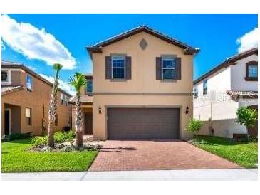 Charming two-story home featuring a brick driveway, neutral exterior, and well-maintained landscaping at 1512 Mumbai Way, Kissimmee, FL 34747