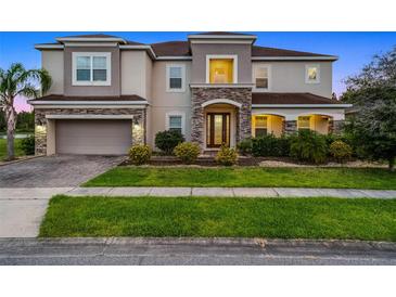 Stunning two-story home featuring a stone facade, well-manicured lawn, and a spacious two-car garage at 2275 Pearl Cider St, Orlando, FL 32824