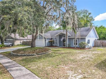 Charming single-story home featuring mature trees, well-maintained lawn, and attached two-car garage at 4274 Meeting Pl, Sanford, FL 32773
