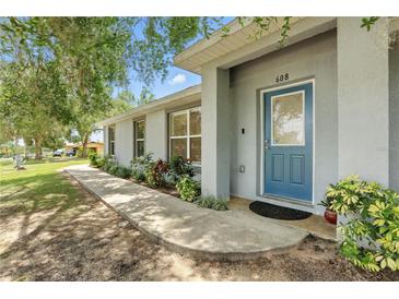 Charming single-story home with a blue front door, well-manicured landscaping, and a welcoming walkway at 608 Swanson St, Groveland, FL 34736