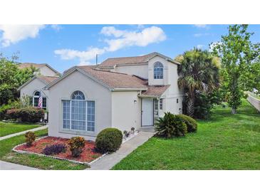 Inviting two-story home with manicured lawn, mature trees, and arched window at 750 Olympic Cir # D1, Ocoee, FL 34761