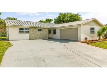 Well-maintained single-story home featuring a spacious driveway and attached garage at 955 Tomes Ct, Orlando, FL 32825
