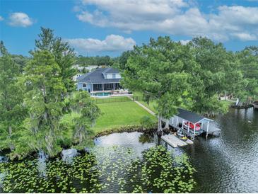Stunning lakefront home featuring a boat house, lush landscaping, and a private swimming pool at 339 Carolyn Dr, Oviedo, FL 32765
