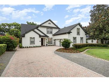Charming two-story home with a brick driveway, lush landscaping, and a well-manicured lawn at 1350 Lyndale Blvd, Winter Park, FL 32789