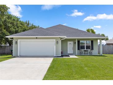 Charming single-story home with a manicured lawn, attached garage, and inviting front porch at 2305 Ascot Ave, Orlando, FL 32833