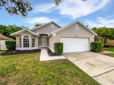 Charming single-story home featuring a well-maintained lawn and a two-car garage at 8994 Fort Jefferson Blvd, Orlando, FL 32822