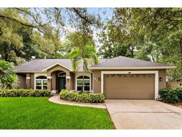 Inviting single-story home with a well-manicured lawn and an attached two-car garage at 917 Southern Oak Ln, Apopka, FL 32712